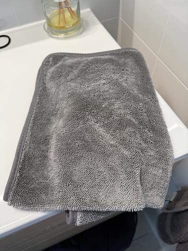 Customer's gray KoalaCloth on a white bathroom vanity next to a reed diffuser