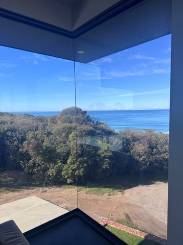 Customer's perfectly clean corner window with a streak-free view of the ocean, cleaned with a KoalaCloth.