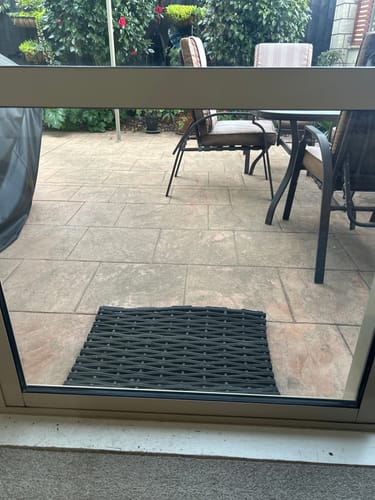 Reviewer's view through a clean, streak-free sliding glass door cleaned with KoalaCloth, looking out onto a patio.